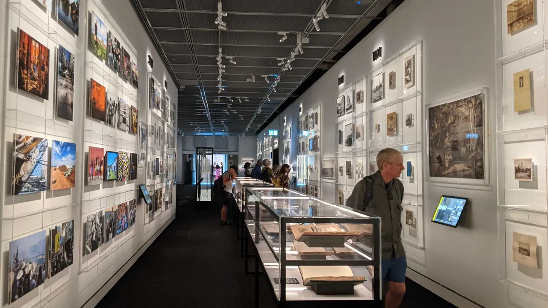 The photographic gallery corridor: hung prints, display cases and kiosks along the walls