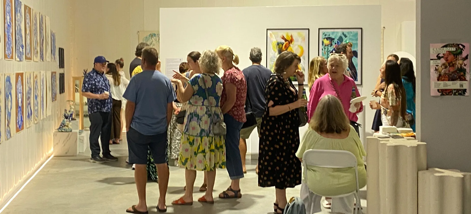 Opening night: visitors gathered in the warehouse gallery among the hung works